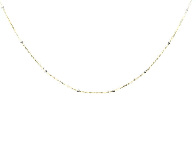 Oro 18k Amarillo, con Bolita de Oro Blanco. Incluye cadena. Largo: 45 cm